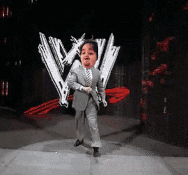 a child in a suit and tie is dancing in front of a wwe logo
