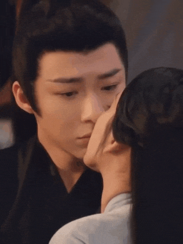 a man and a woman are kissing in a room .