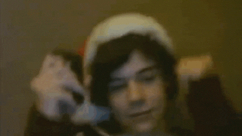 a man wearing a santa hat is holding a cell phone in his hand .