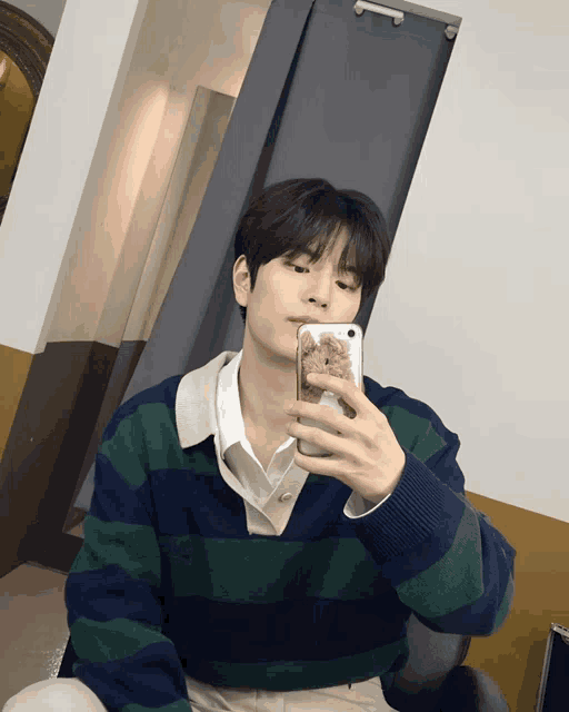 a young man taking a selfie with his phone