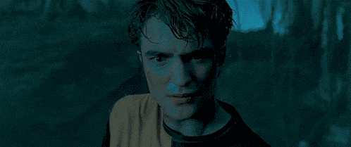 a close up of a young man 's face in a dark room