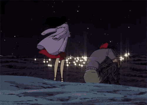 a man and a woman are standing in the snow looking at christmas lights