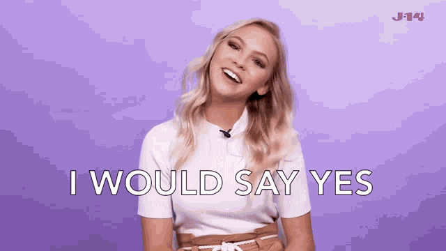a woman says i would say yes in front of a purple wall