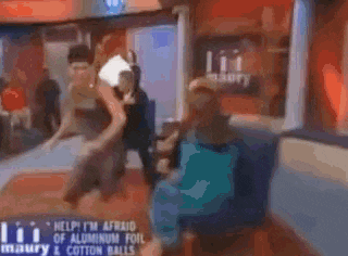 a blurry picture of people standing in a room with a sign that says help fm afraid of aluminum foil injury