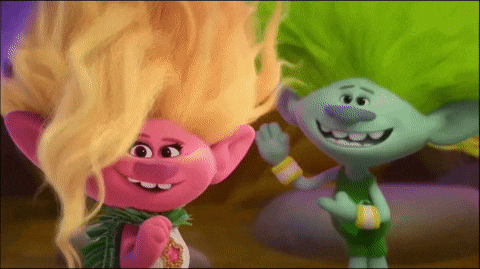 a couple of trolls standing next to each other and smiling .