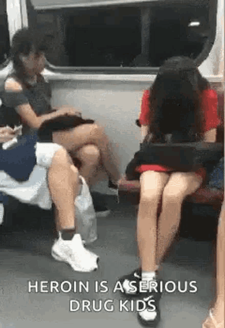 a group of people are sitting on a subway car .