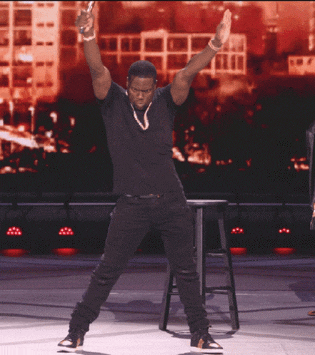 a man in a black shirt is dancing on stage