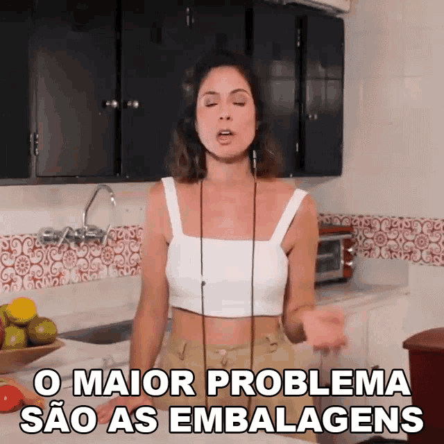 a woman in a white crop top says o maior problema sao as embalagens in a kitchen