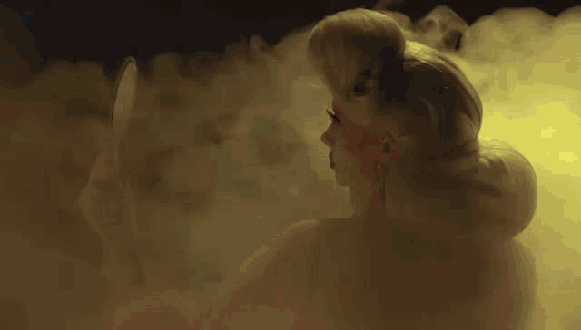 a woman is standing in a dark room with smoke coming out of her hair .