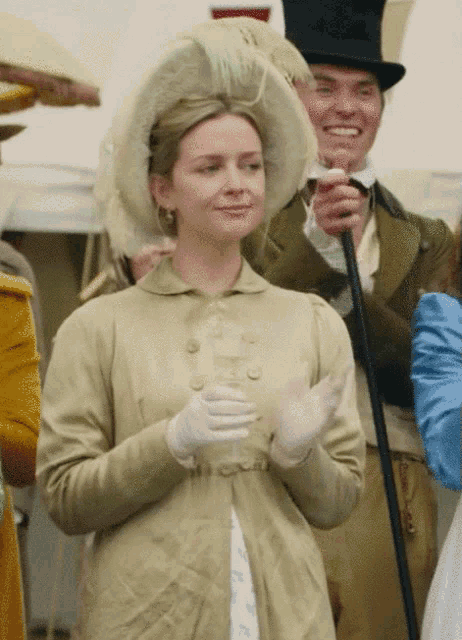 a woman in a hat and gloves is clapping her hands