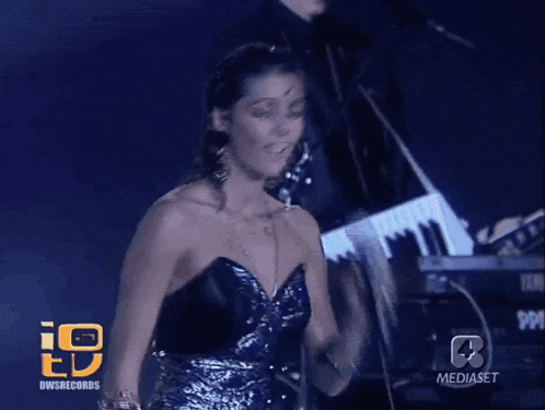 a woman singing in front of a keyboard that says yamaha