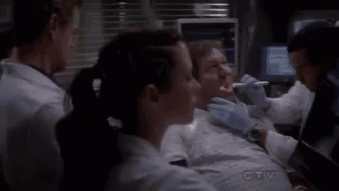 a man is having his teeth examined by a dentist in a hospital room .