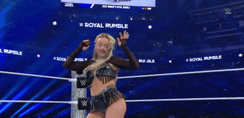 a woman in a wrestling ring with the words royal rumble on the walls