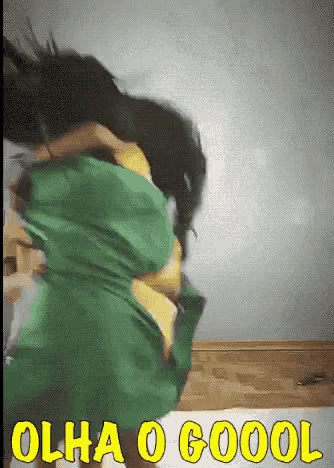 a woman in a green shirt is jumping in the air with the words olha o goool in yellow letters