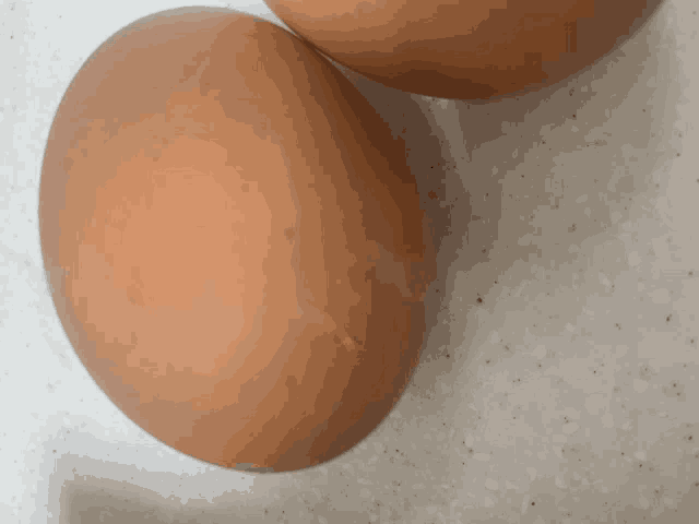 two brown eggs are on a white counter top