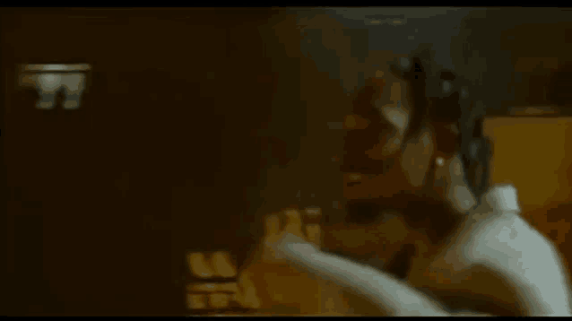 a man with dreadlocks is standing in a dark room in a dark room .