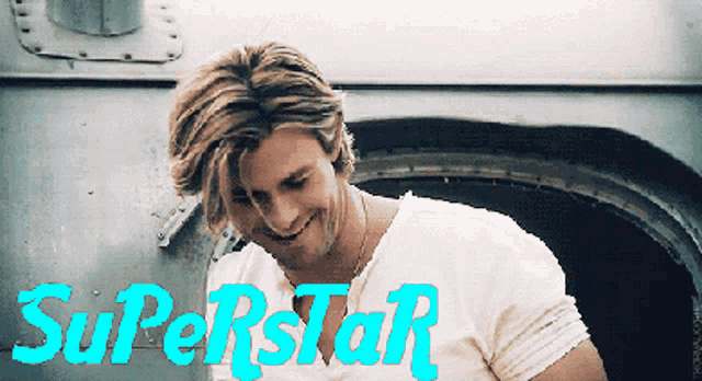 a man in a white shirt is smiling with the words superstar behind him