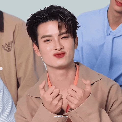 a close up of a man making a heart shape with his hands and the words khunpol gif below him