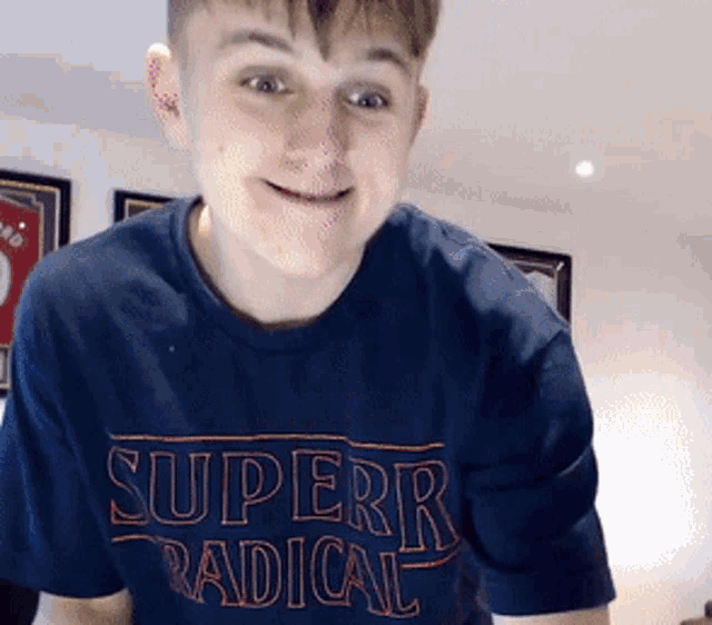 a young man is wearing a blue shirt that says superr radical