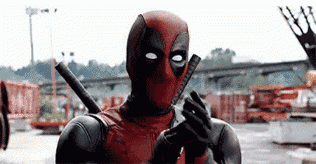 a man in a deadpool costume is holding a gun and a knife .