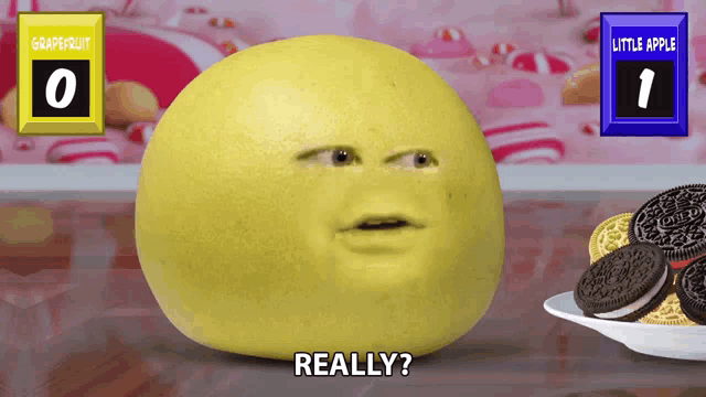 a grapefruit with a face on it is next to a plate of oreo cookies