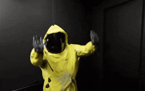 a person wearing a yellow suit and a helmet is dancing in a dark room .