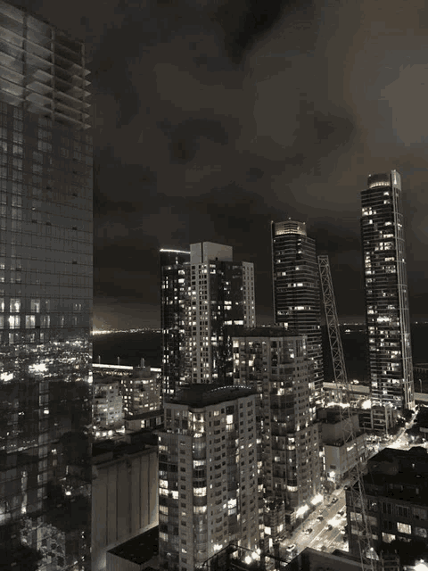 a view of a city at night with a few buildings including one that says ' allianz ' on it