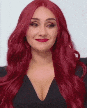 a woman with long red hair is wearing a black dress and red lipstick