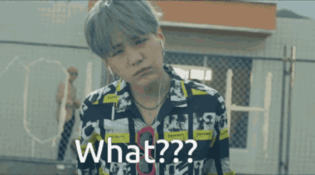 a man wearing headphones and a shirt that says " what " on it
