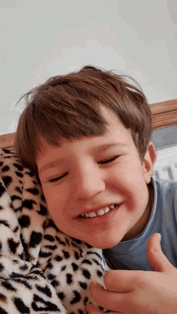 a young boy is giving a thumbs up and smiling