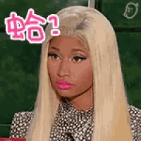 a woman with blonde hair and pink lips is wearing a black and white dress and making a funny face .