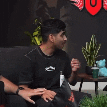 a man sits on a couch with his hands over his mouth