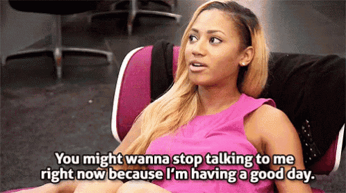a woman in a pink dress is sitting in a chair and talking to someone while having a good day .