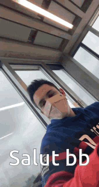 a man wearing a face mask says salut bb on the bottom
