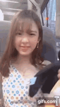 a woman in a polka dot dress is sitting in a car and smiling