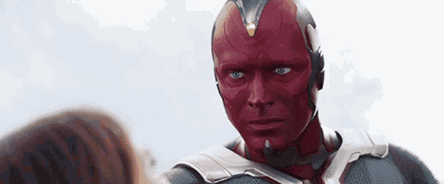 a close up of a man with a red mask on his face looking at a woman .