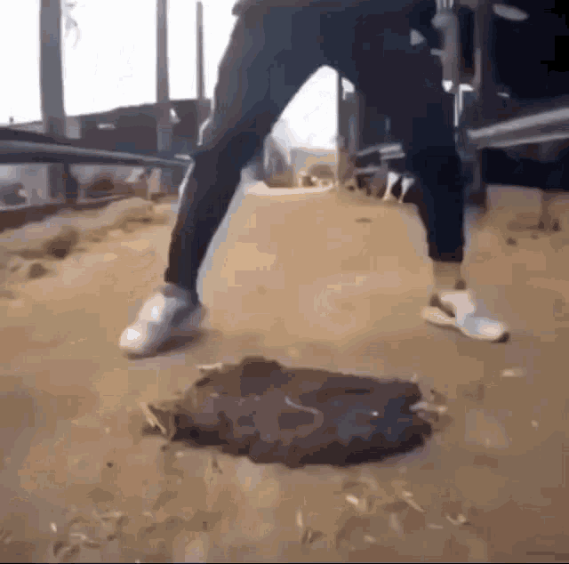 a man is standing on a hole in the ground .