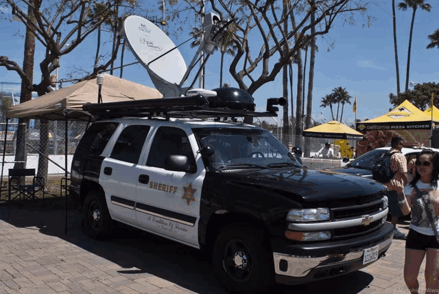 a sheriff 's vehicle is parked in front of a tent