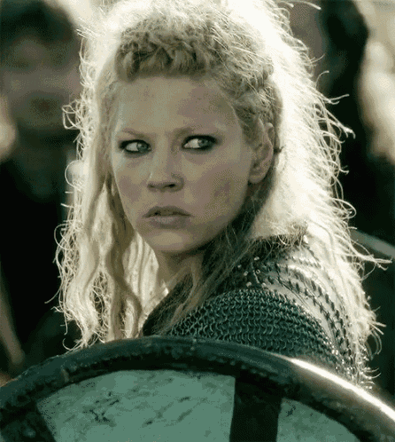 a woman with blonde hair is holding a shield