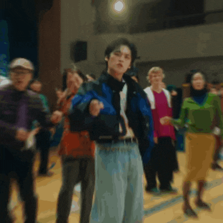 a man in a blue jacket is standing in front of a group of people