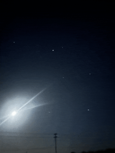 the moon is shining brightly in the dark sky
