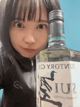 a woman is holding a bottle of liquor that says iu2 on it