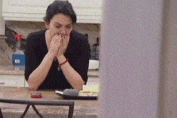 a woman sitting at a counter with her hands on her face