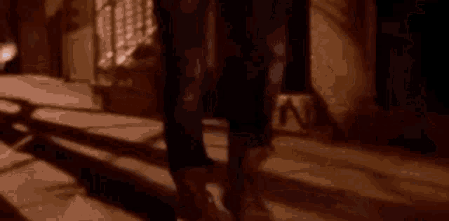 a young man wearing a hat is standing on a street at night .