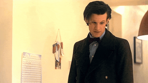 a man in a suit stands in front of a calendar