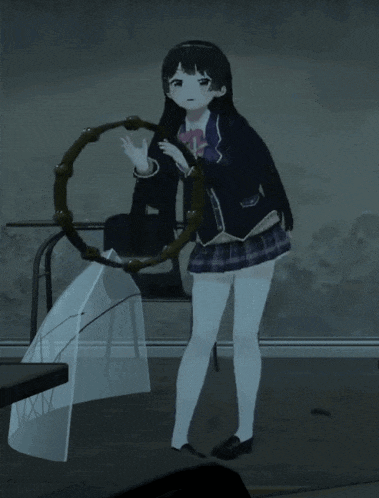 a girl in a school uniform holds a tambourine in front of her face
