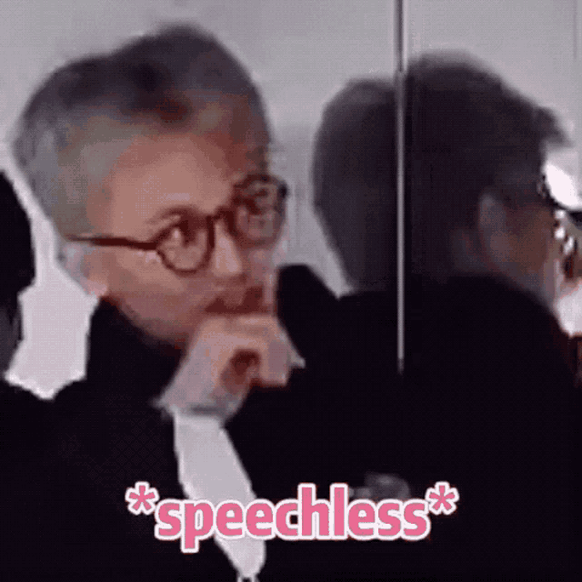 a man wearing glasses is sitting in front of a mirror with the word speechless written on the bottom