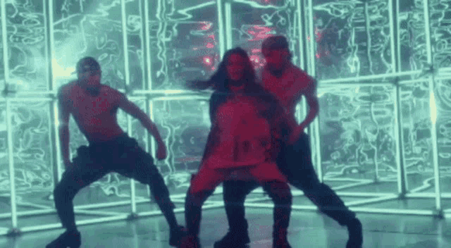 a group of people are dancing in front of a wall with neon lights