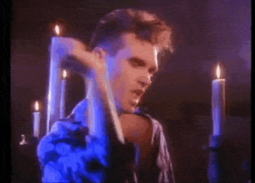 a man is standing in front of a row of candles .
