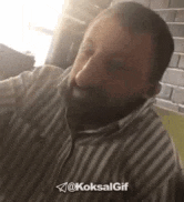 a man with a beard is taking a selfie with the sun shining on his face .